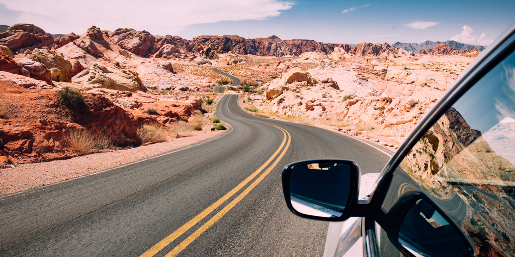 A Car Driving Through Desert Roads On A Road Trip