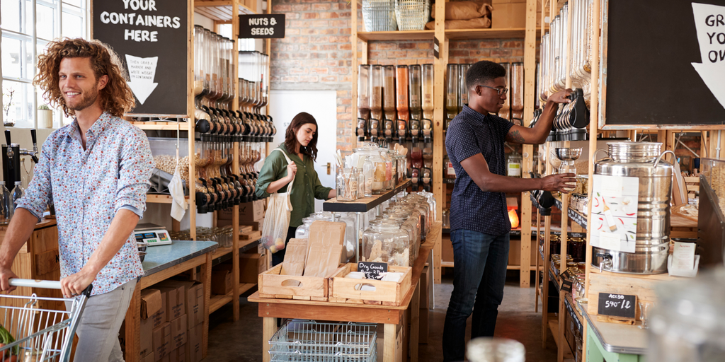 Shoppers in a plastic-free grocery store, filling containers with bulk foods and embracing zero-waste practices.